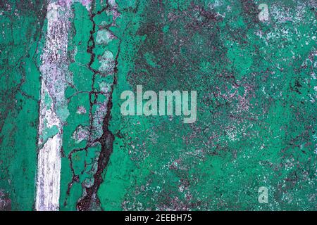 Green cracked asphalt with white line, top view photo. Cement floor top view photo texture. Rustic surface vintage background. Painted weathered surfa Stock Photo