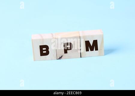 Acronym BPM - Business process management. Wooden small cubes with letters isolated on yellow background. Business Concept image Stock Photo