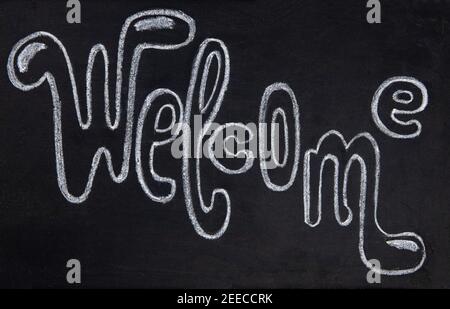Welcome handdrawn chalk lettering inscription on blackboard. Welcome handwritten sign on chalkboard. Welcoming tag for coffee shop or bar. Hipster caf Stock Photo