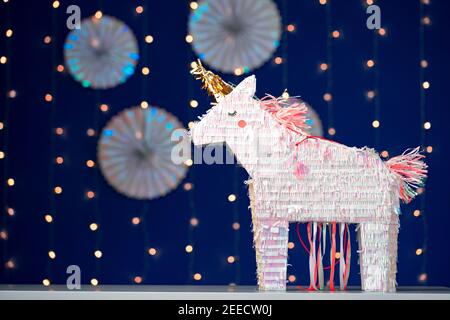 Unicorn party pinata on blue bokeh background Stock Photo