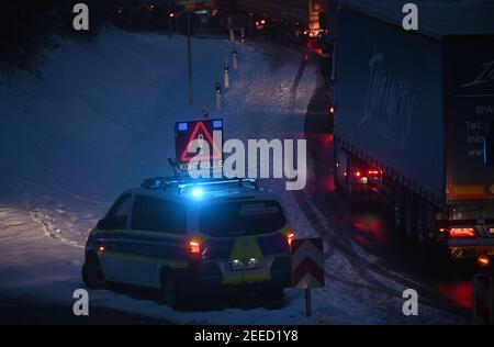 Waidhaus, Germany. 16th Feb, 2021. A police car announces a check at the German-Czech border in the early morning, vehicles are jammed next to it. Germany's stricter entry rules at the border with the Czech Republic to protect against dangerous variants of the coronavirus came into force in the night of 14.02.2021. Credit: Armin Weigel/dpa/Alamy Live News Stock Photo