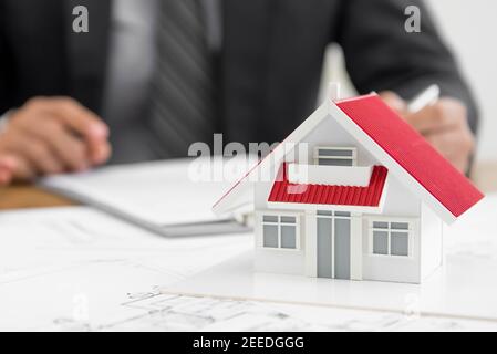 Architect (or real estate agent) working on house model and design layout for a proposal Stock Photo