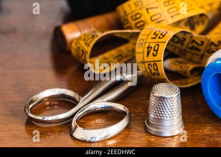 Close-up of thread, tape measure, scissors, thimble and dressmaker's objects. Stock Photo
