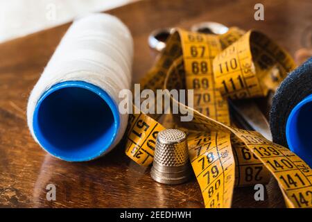 Close-up of thread, tape measure, scissors, thimble and dressmaker's objects. Stock Photo