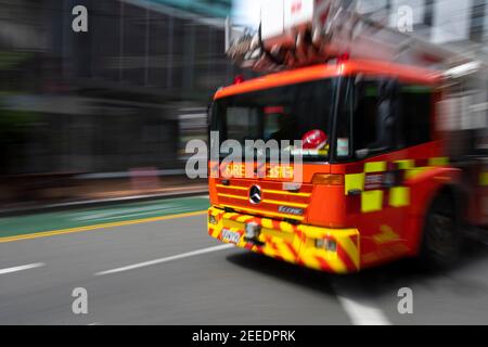 Fire engine speeding through central city, Wellington, North Island, New Zealand Stock Photo