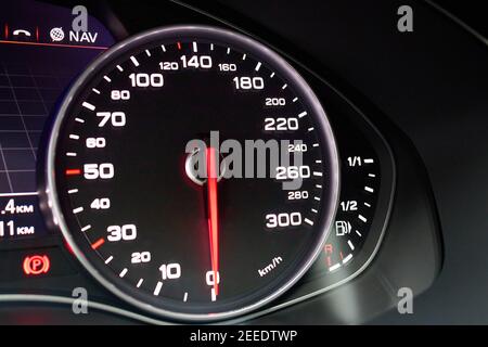 Electronic dashboard of modern luxury car view from aside. Speedometer shows speed in kilometers per hour and fuel control, parking and GPS system Stock Photo