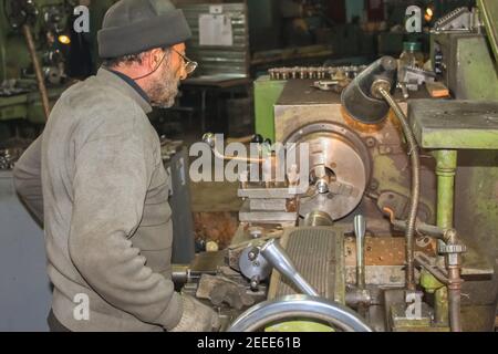 The turner processes the part in the lathe Stock Photo