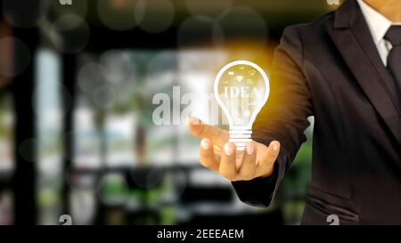 Businessman holding a light bulb idea of financial ideas, investing and running a successful business. Stock Photo