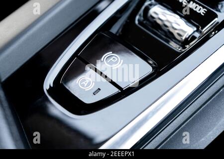 Detail of a parking brake in a nodern car. Electronic parking brake button in a modern car. Button closeup. Stock Photo