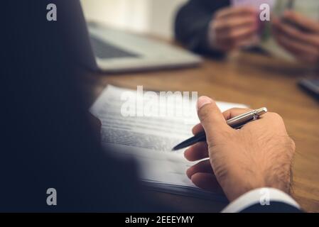 Businessman hand holding pen about to sign contract Stock Photo