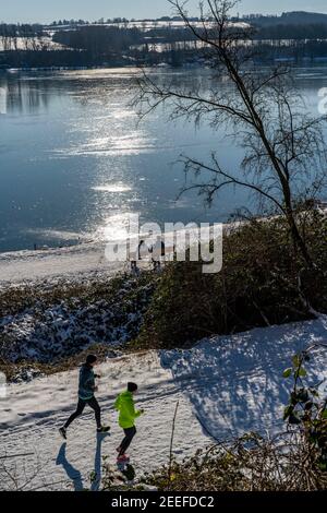 Winter in the Ruhr area, Baldeneysee, snow-covered, partly frozen lake, walkers on the shore path, west bank, Essen, NRW, Germany, Stock Photo