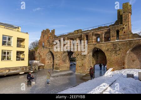 ZUTPHEN, NETHERLANDS - Feb 14, 2021: Snow and ice at the Berkelpoort entrance city wall against a vibrant clear blue sky Stock Photo