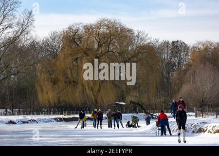 ZUTPHEN, NETHERLANDS - Feb 14, 2021: Winter barren trees and snow landscape with ice skaters on frozen river Berkel Stock Photo