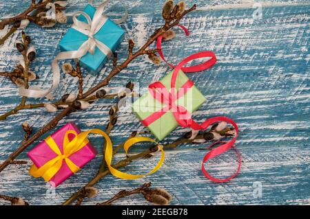 Willow twigs. Holy Easter. Blue turquoise background. Gift boxes with origami ribbons. Stock Photo