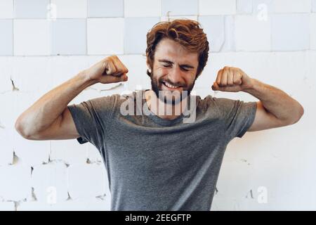 Pleased joyful bearded man against rough wall Stock Photo