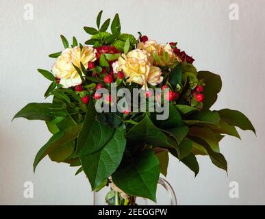 Bouquet of flowers, green red yellow white and pink colors with big green leafs Stock Photo