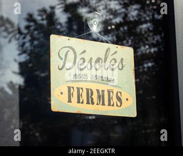 Sign on shop window reads 'sorry, we are closed', in France Stock Photo