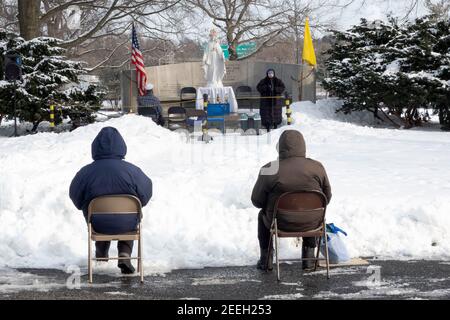 BAYSIDERS> Devout Christians attend a winter afternoon mass in a park in Queens New York at the site of the 1964 Worlds Fair Vatican Pavilion. Stock Photo