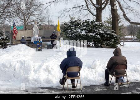 BAYSIDERS> Devout Christians attend a winter afternoon mass in a park in Queens New York at the site of the 1964 Worlds Fair Vatican Pavilion. Stock Photo