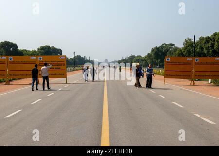 New Delhi, India. 15th Feb, 2021. People walk past large metal sheets at a construction site.Central Vista Avenue Redevelopment Project begins near Rajpath Under the redevelopment of the 3 km long Central Vista Avenue in Lutyens Delhi. Credit: SOPA Images Limited/Alamy Live News Stock Photo