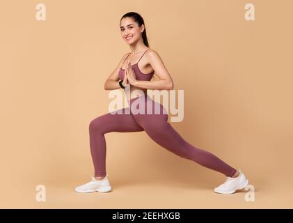 Sporty yogi woman stretching legs doing warmup Stock Photo