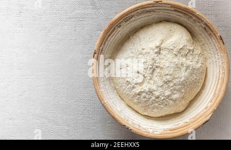 The process of raising the dough in a special basket. Dough made from natural sourdough. Wheat dough. Fermentation. Stock Photo