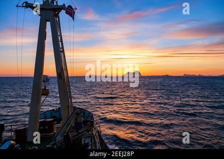 Sunset over a rocky archipelago from a ship on the sea Stock Photo