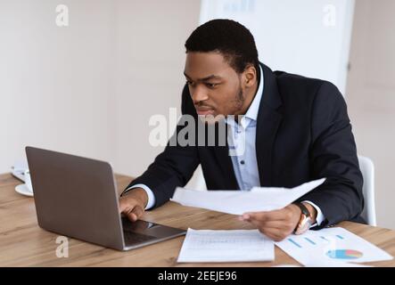 African american manager checking marketing report, using laptop Stock Photo