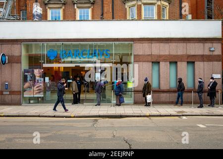 London- People queueing whilst social distancing outside Barclays bank Ealing Broadway branch Stock Photo