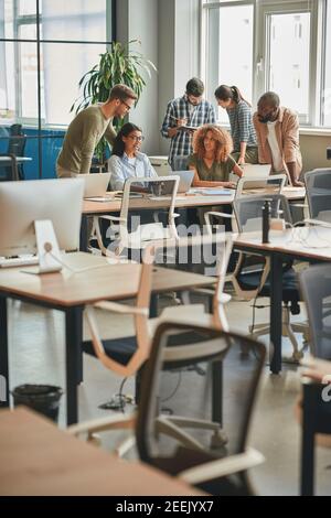 Strong team of young professionals working together in modern office Stock Photo