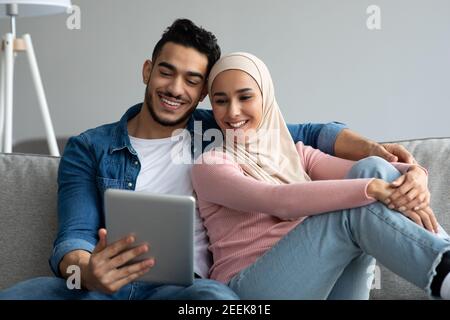 Happy middle-eastern couple looking at digital tablet screen Stock Photo