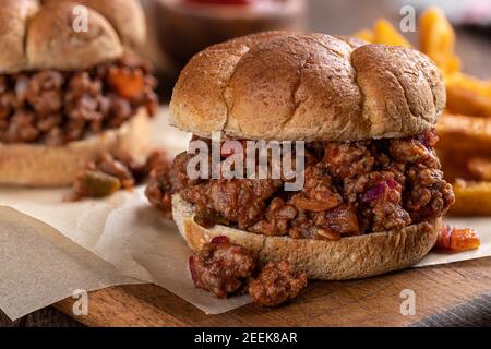 Closeup of a sloppy joe sandwich and french fries on a wooden cutting board Stock Photo