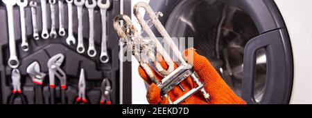 Treatment of Calcium Deposits in Water Heater. Limescale on the heating element for washing machine. Replacing a heating element. Stock Photo