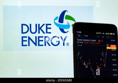 In this photo illustration, the stock market information of Duke Energy Corporation seen displayed on a smartphone while the Duke Energy Corporation logo in the background. Stock Photo