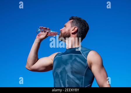 man need hydration. sports and healthy lifestyle routine. water balance in body. athlete feel thirsty after exercise. sportsman drinking from bottle. health care. muscular guy drink water after sport. Stock Photo