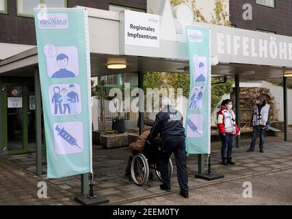 Nettersheim, Germany. 16th Feb, 2021. An employee pushes a man in a wheelchair into the Kommunale Impfzentrum Euskirchen. Credit: Oliver Berg/dpa/Alamy Live News Stock Photo