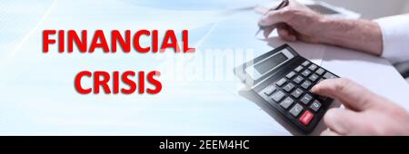Concept of financial crisis with businessman using calculator at office; panoramic banner Stock Photo