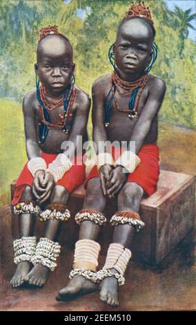 An early 20th century photo of a pair of young Nigerian girls decorated with hippo ivory and cowrie shell bracelets circa 1909 photographed by Northcote Whitridge Thomas British Government Anthropologist Stock Photo