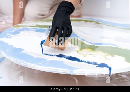 Artistic background. Round canvas with dripping paint. The process of creating a painting using fluid art technique. close-up Stock Photo