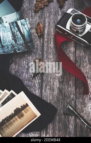 Camera and old photographs on old wooden background and blue and red fabrics Stock Photo
