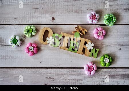 Wooden sign with an Easter bunny with flowers as decoration. The Text is German for Easter. Stock Photo
