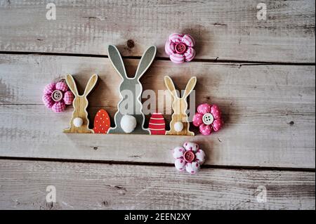 Three wooden Easter bunnies from behind with decoration. Stock Photo