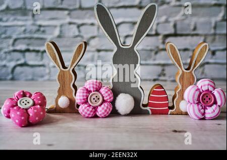 Three wooden Easter bunnies from behind with decoration. Stock Photo