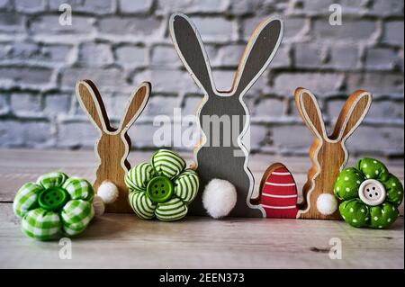 Three wooden Easter bunnies from behind with decoration. Stock Photo