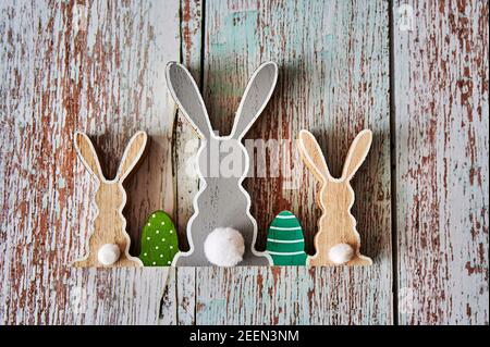 Three wooden Easter bunnies from behind with decoration. Stock Photo