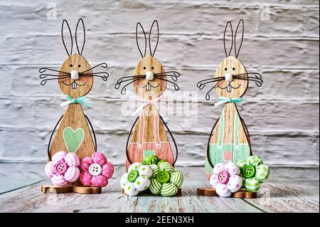 Three wooden Easter bunnies with decoration. Stock Photo
