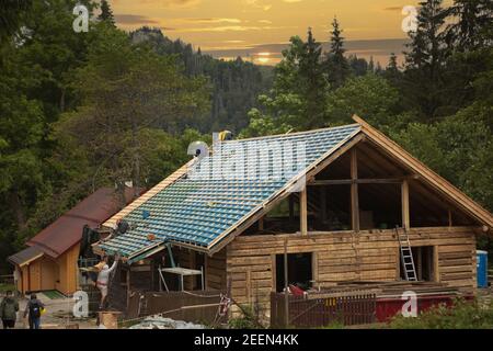 ZAKOPANE, POLAND - Aug 19, 2020: Roofers at work -  male builder performs work on the roof. Stock Photo