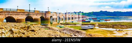 Scenic mountain and sea panoramic landscape in northern Spain.Green meadows and boats under the medieval stone bridge Stock Photo