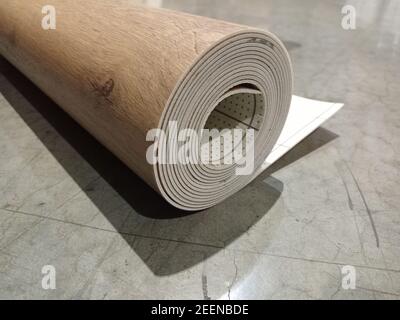 Linoleum rolled up. Linoleum roll with wood texture. Stock Photo