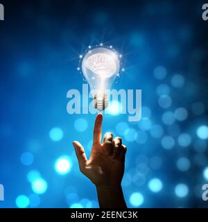 Businessman fingertip on Light bulbs with Brain inside and Low poly wireframe outside. Business Bright idea concept Stock Photo